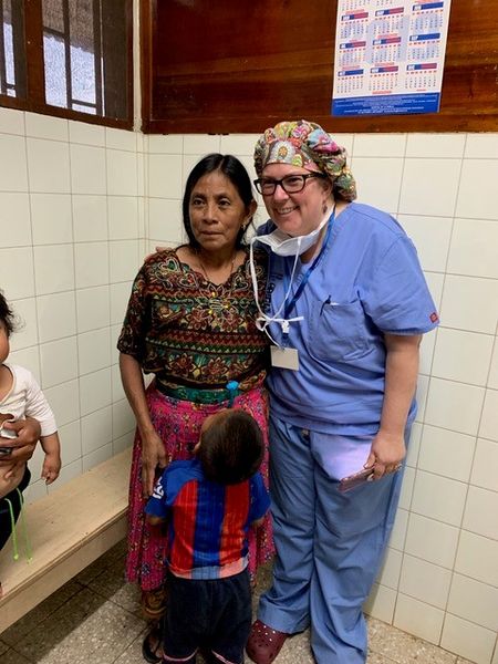 Hospital de la Familia Foundation doc volunteers in scrubs with local Guatemalan woman